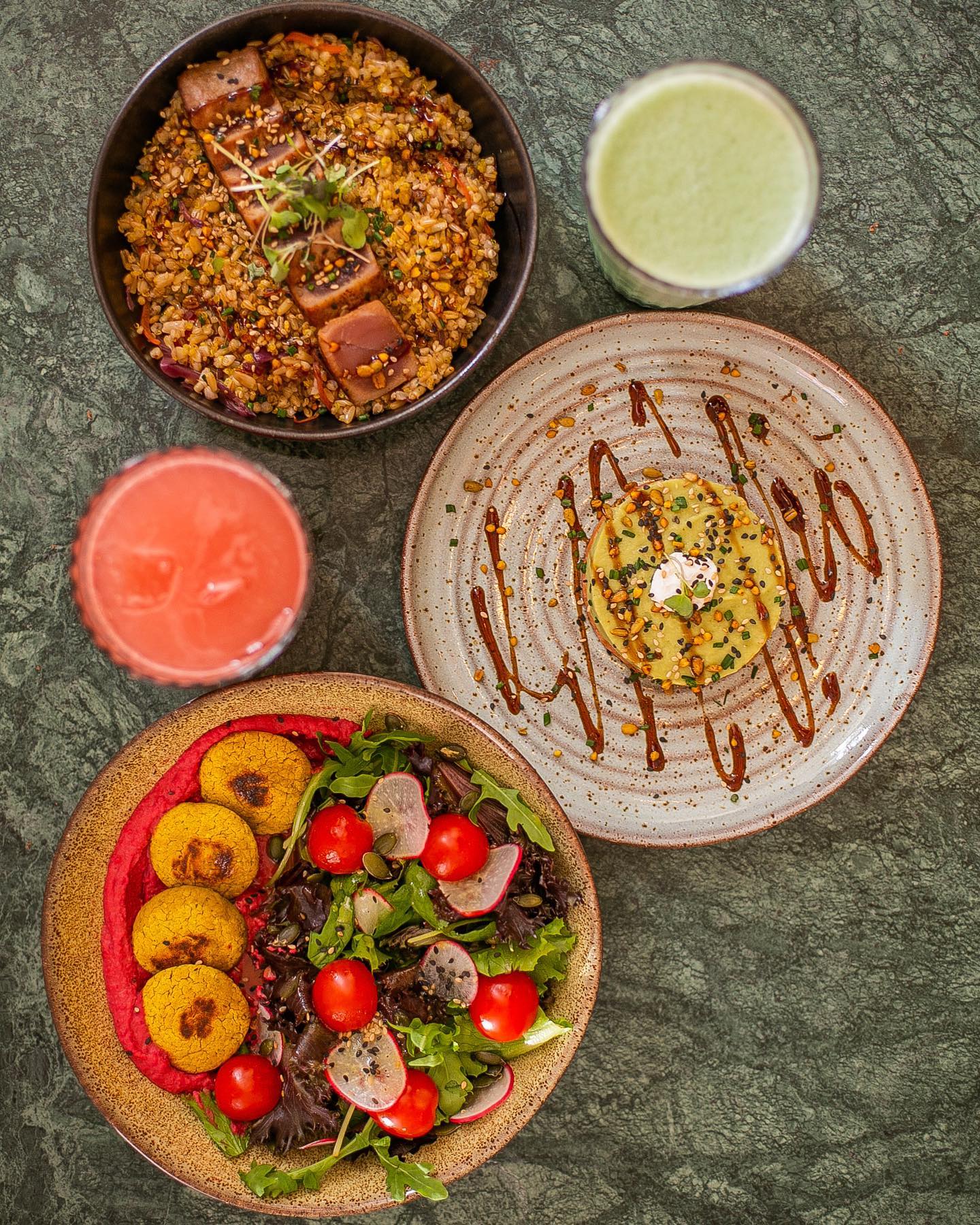 Colorful bowls with falafel salad, salmon tartare and tuna